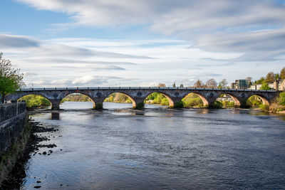 Arch bridge over river against sky