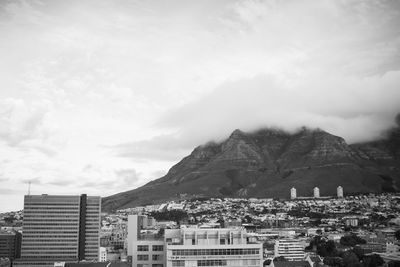 Buildings in city against cloudy sky