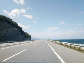 Road by sea against sky