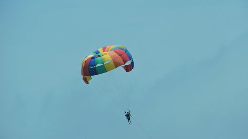 Low angle view of person paragliding against clear sky