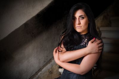 Portrait of beautiful young woman against wall