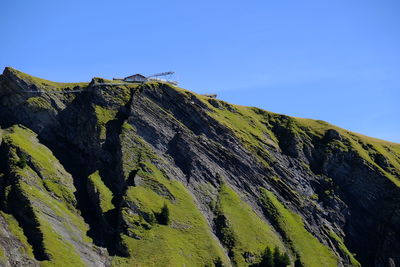 Low angle view of rocks against clear blue sky