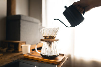 Hand pouring coffee in cup