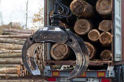 Crane loading logs at truck lumberyard