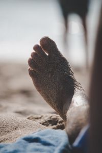 Close-up of man hand on sand