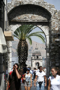 People walking by building in city