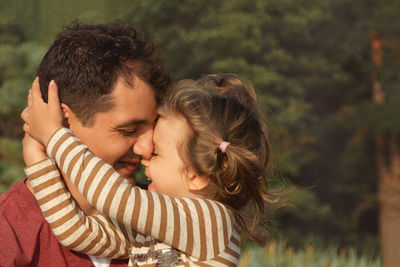 Close-up of father embracing with daughter outdoors
