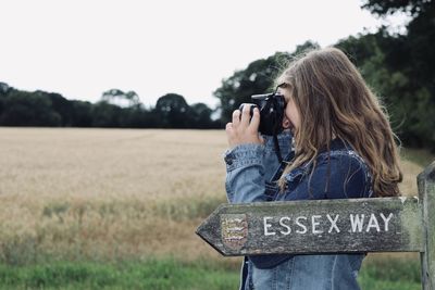 Woman photographing on field