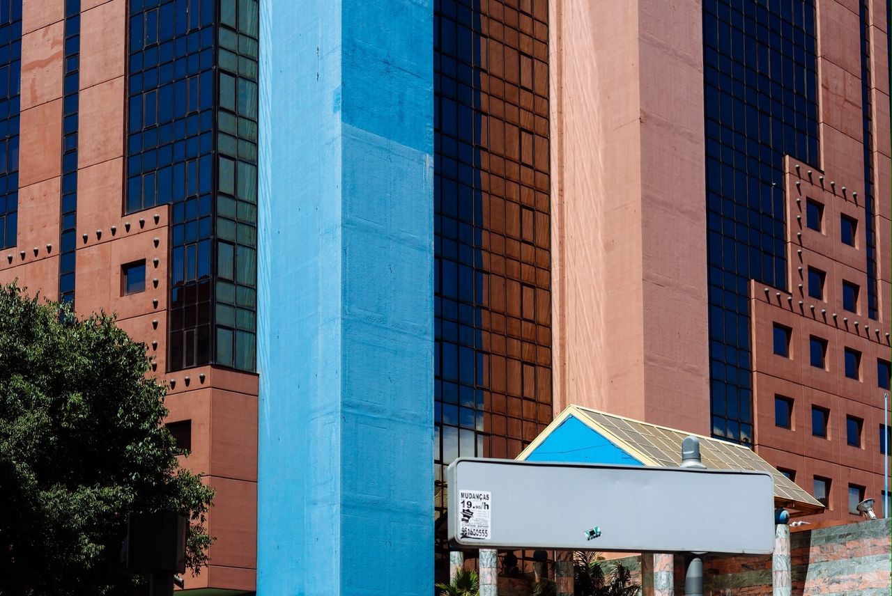 building exterior, architecture, built structure, city, building, window, office building, modern, residential building, low angle view, tree, residential structure, reflection, city life, skyscraper, apartment, outdoors, blue, glass - material, day