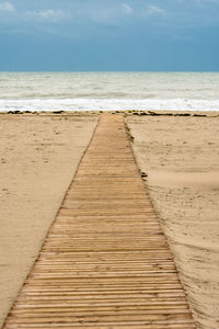 Boardwalk on beach against sky