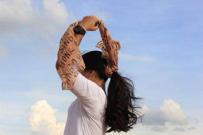 Low angle view of woman standing against sky
