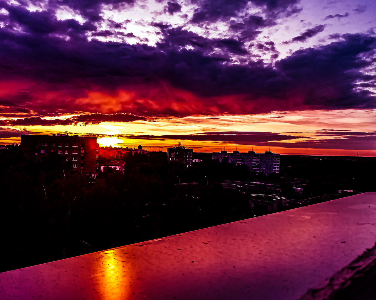 ILLUMINATED CITYSCAPE AGAINST SKY DURING SUNSET