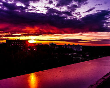 Illuminated buildings against sky during sunset