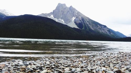 Scenic view of sea by mountains against sky