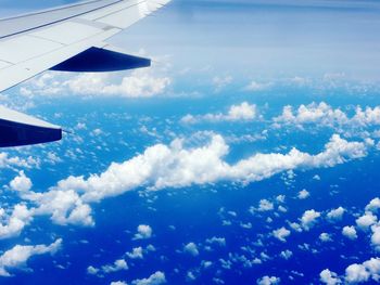 Aerial view of airplane wing over clouds