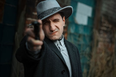 Portrait of young man wearing hat standing outdoors