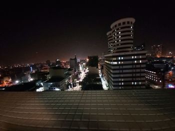 Illuminated buildings in city against sky at night