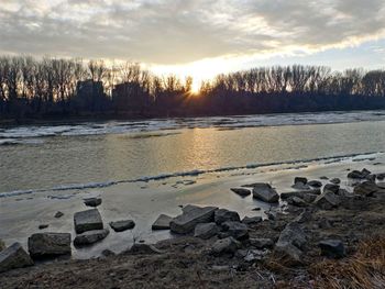 Scenic view of frozen lake against sky during sunset