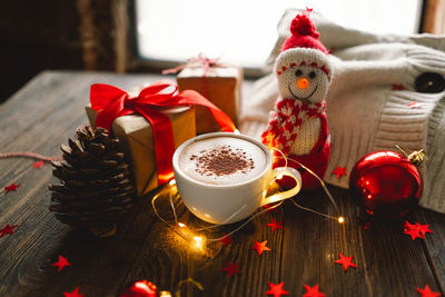 Christmas cup of coffee with sweater and christmas decorations.