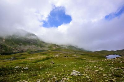 Scenic view of mountains against cloudy sky