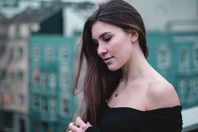 Portrait of young woman looking away outdoors