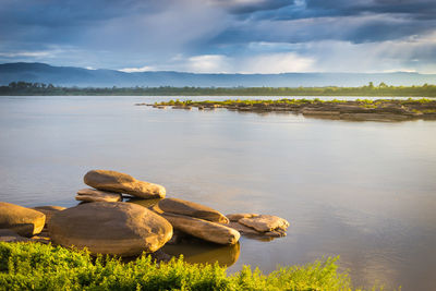 Scenic view of rocks by lake against sky