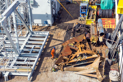 Offshore worker inspecting rigging at anchors on the deck of a construction barge at oil field