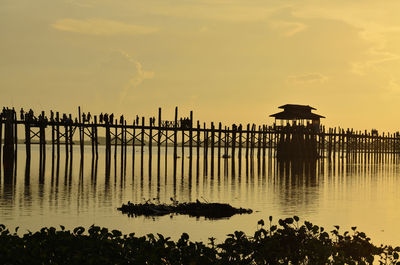 Silhouette pier on sea against sky during sunset