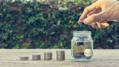 Close-up of hand holding glass jar against blurred background