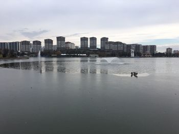 Buildings by sea against sky