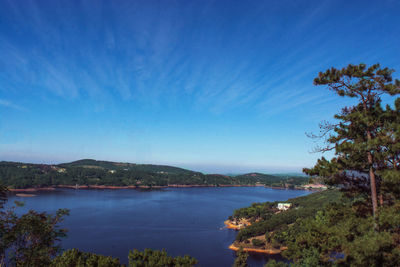 Scenic view of river against blue sky