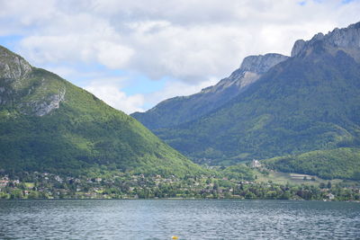 Scenic view of lake by mountains against sky