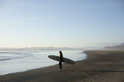 Surfer girl on the beach near tofino