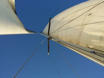 Low angle view of power lines against clear blue sky