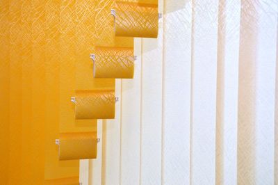 Close-up of clothes hanging on yellow wall at home