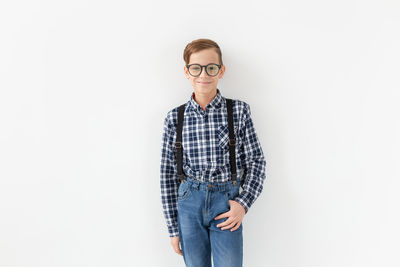 Portrait of teenage boy standing against white background