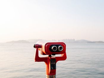 Close-up of coin operated binoculars facing sea