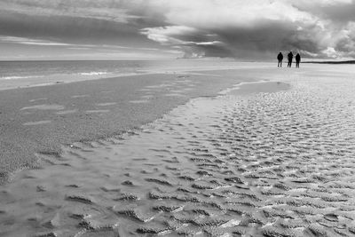 People on beach against sky