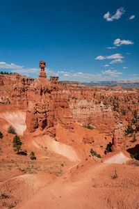 Rock formations on landscape against blue sky