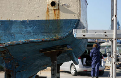 Rear view of man working on boat