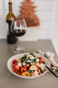 Italian pancanella salad in deep plate. fresh heirloom tomatoes. red wine in glass.