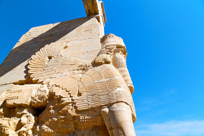 Low angle view of statue against blue sky