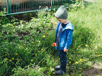 Child is going to water the seedlings in the garden. gardening with children