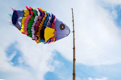 Low angle view of fish decoration against cloudy sky