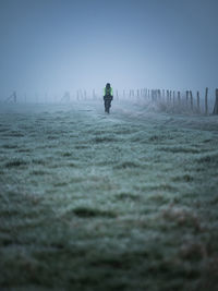 Silhouette person cycling on field