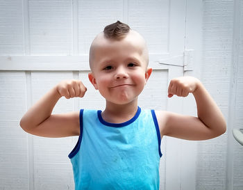 Portrait of cute boy with a double biceps pose