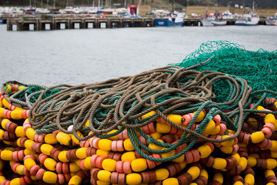 Close-up of fishing net on pier at harbor