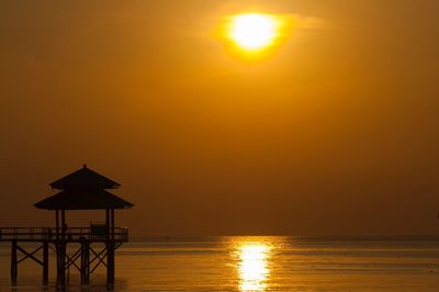 Scenic view of sea against orange sky