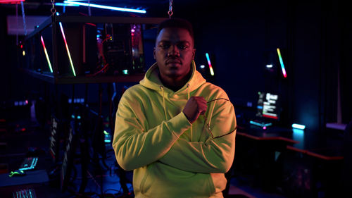 Portrait of young man standing in internet cafe