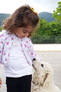 Girl with dog against mountain